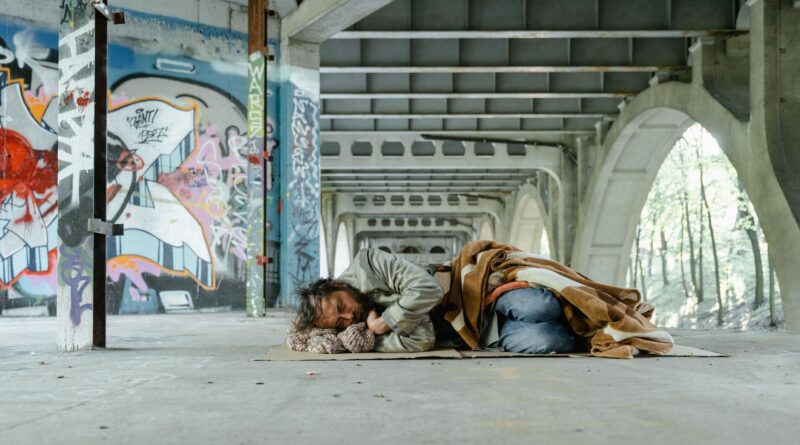 a man sleeping on a cardboard